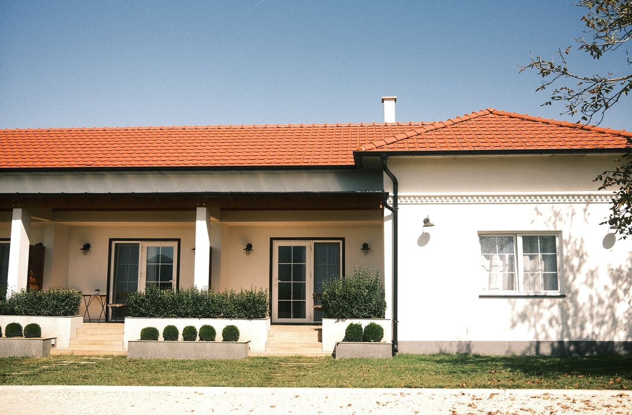 A family home with a covered porch and garden, protected by a security system